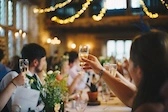 Menschen, die Ihre Gläser heben nachdem ein Toast ausgesprochen wurde